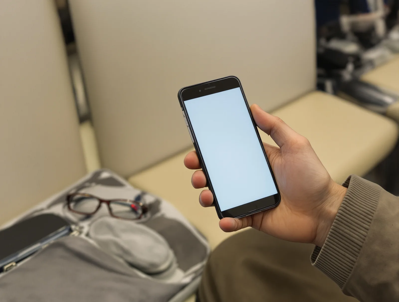 待合室でスマートフォンを持つ手