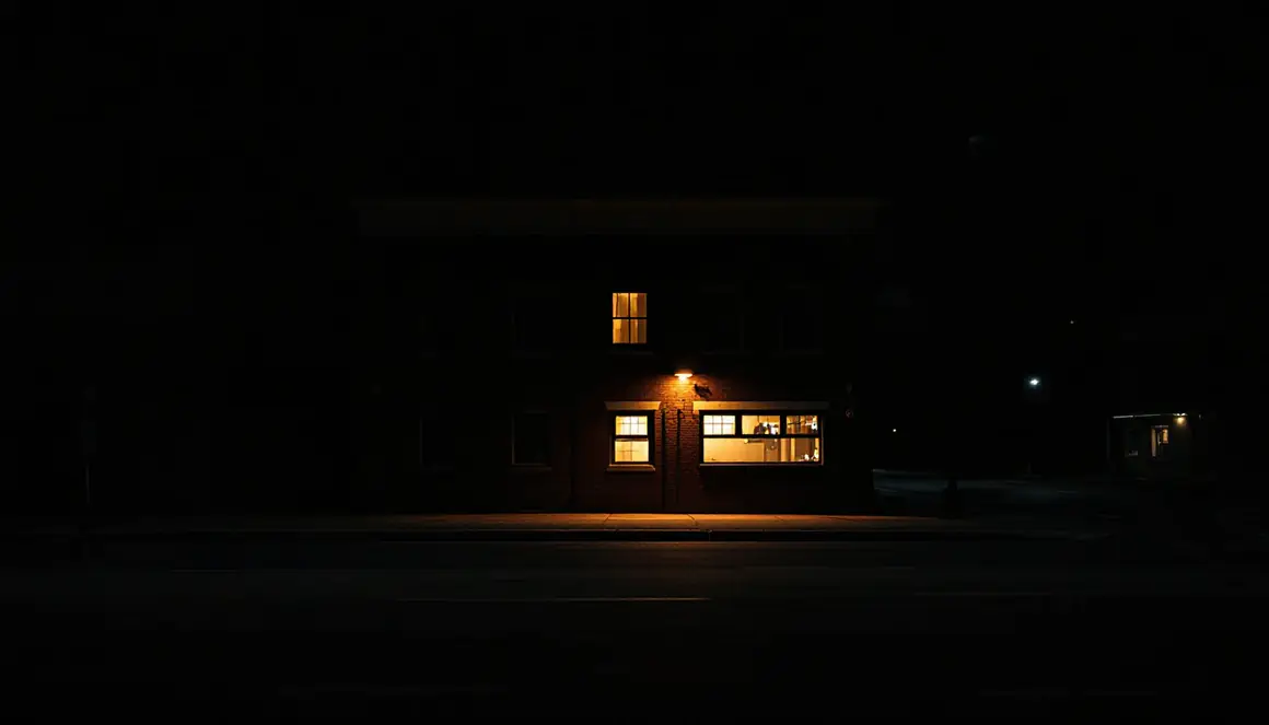 夜の通りから見た建物。ひとつの窓だけに灯りがついている